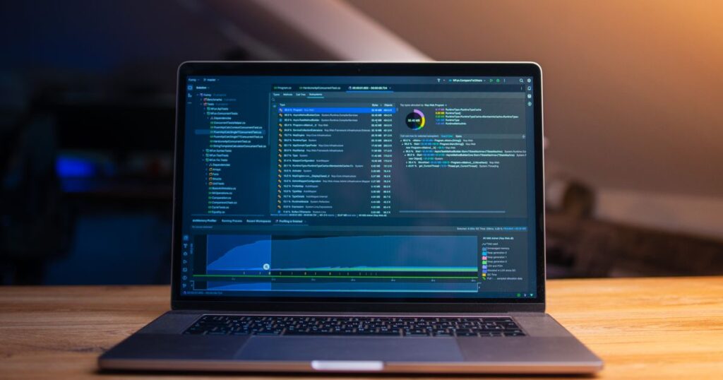Laptop open to a code editor on a wooden desk, representing WordPress software updates